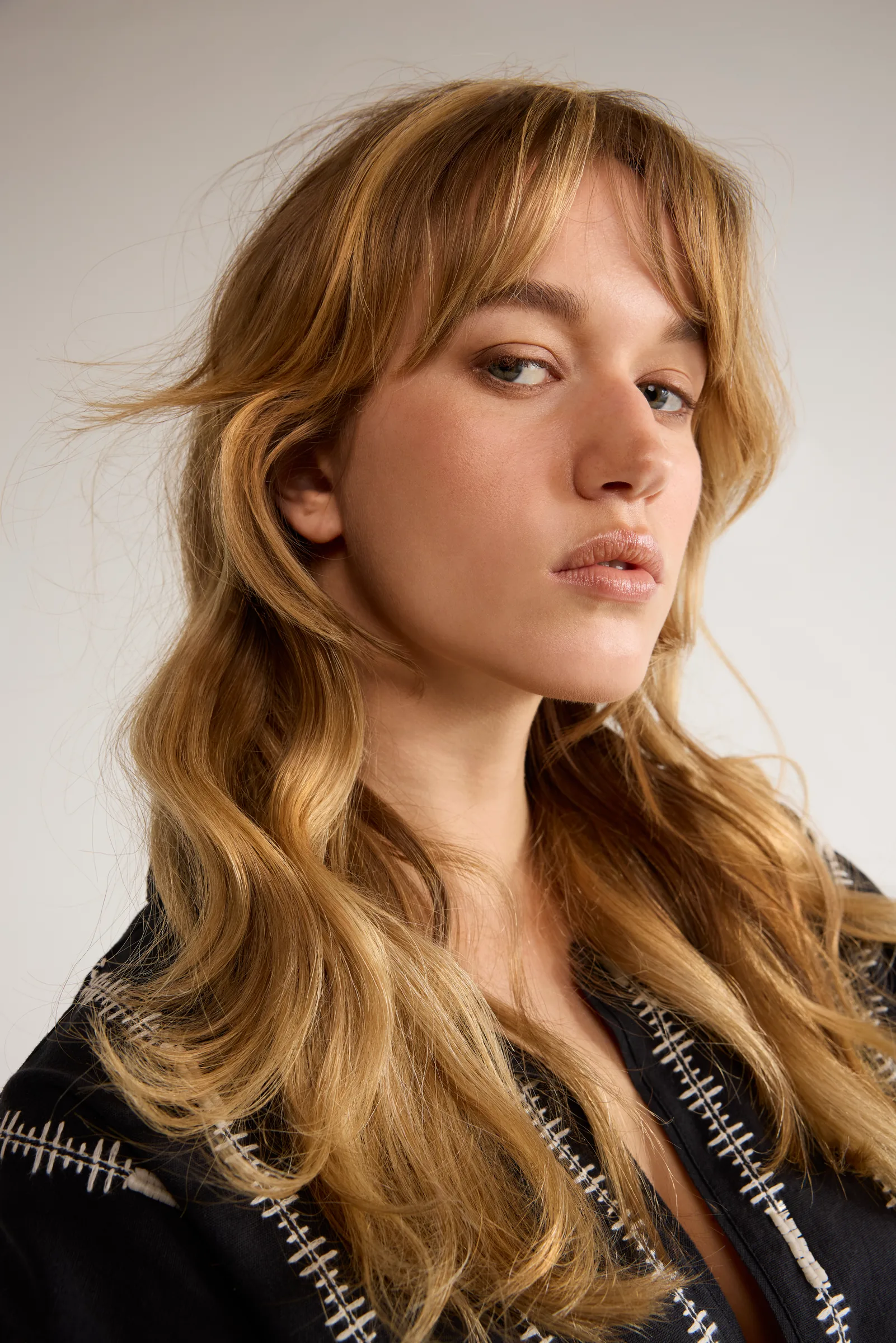 Model with long wavy hair in a patterned jacket