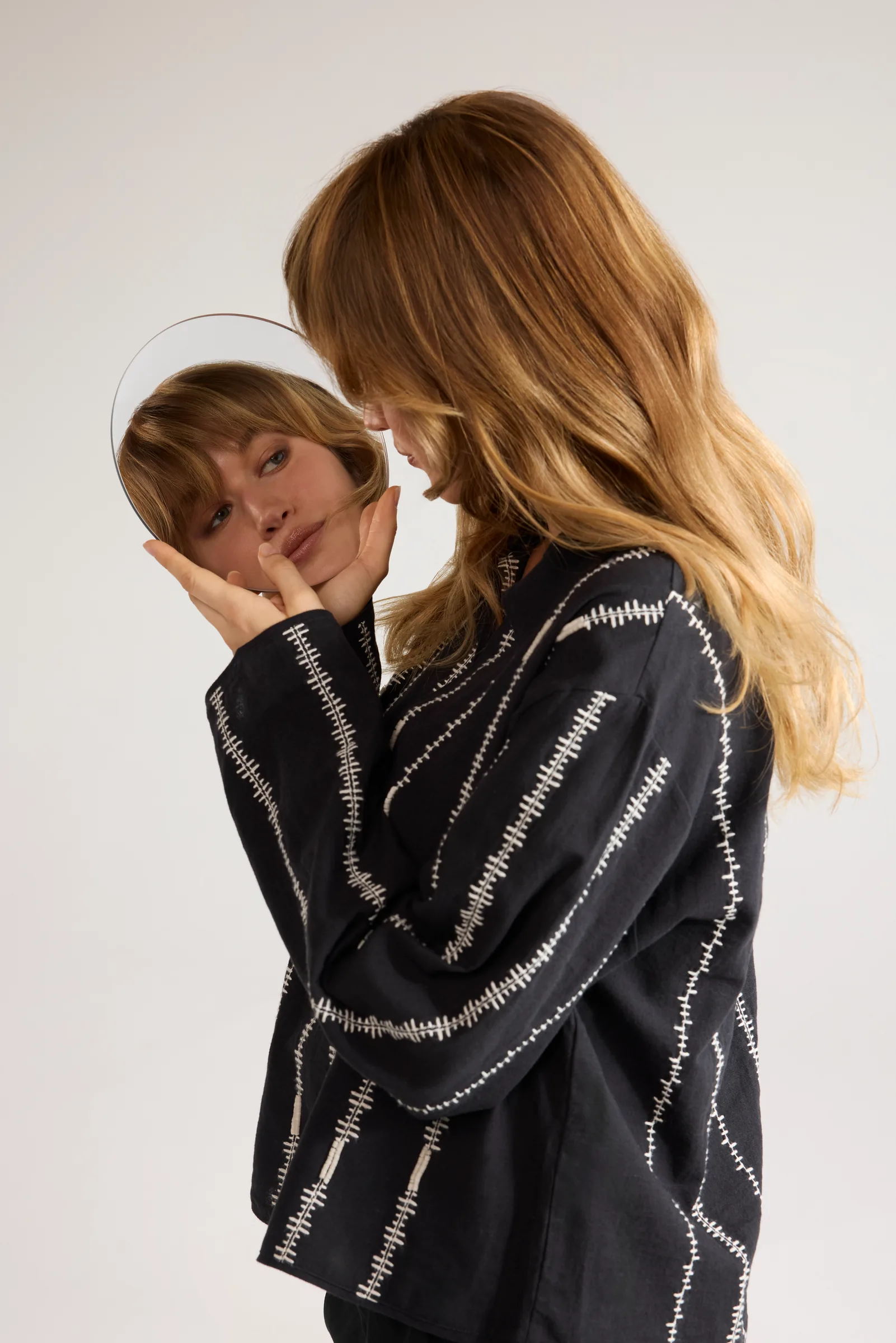 Model holding a mirror that reflects her face