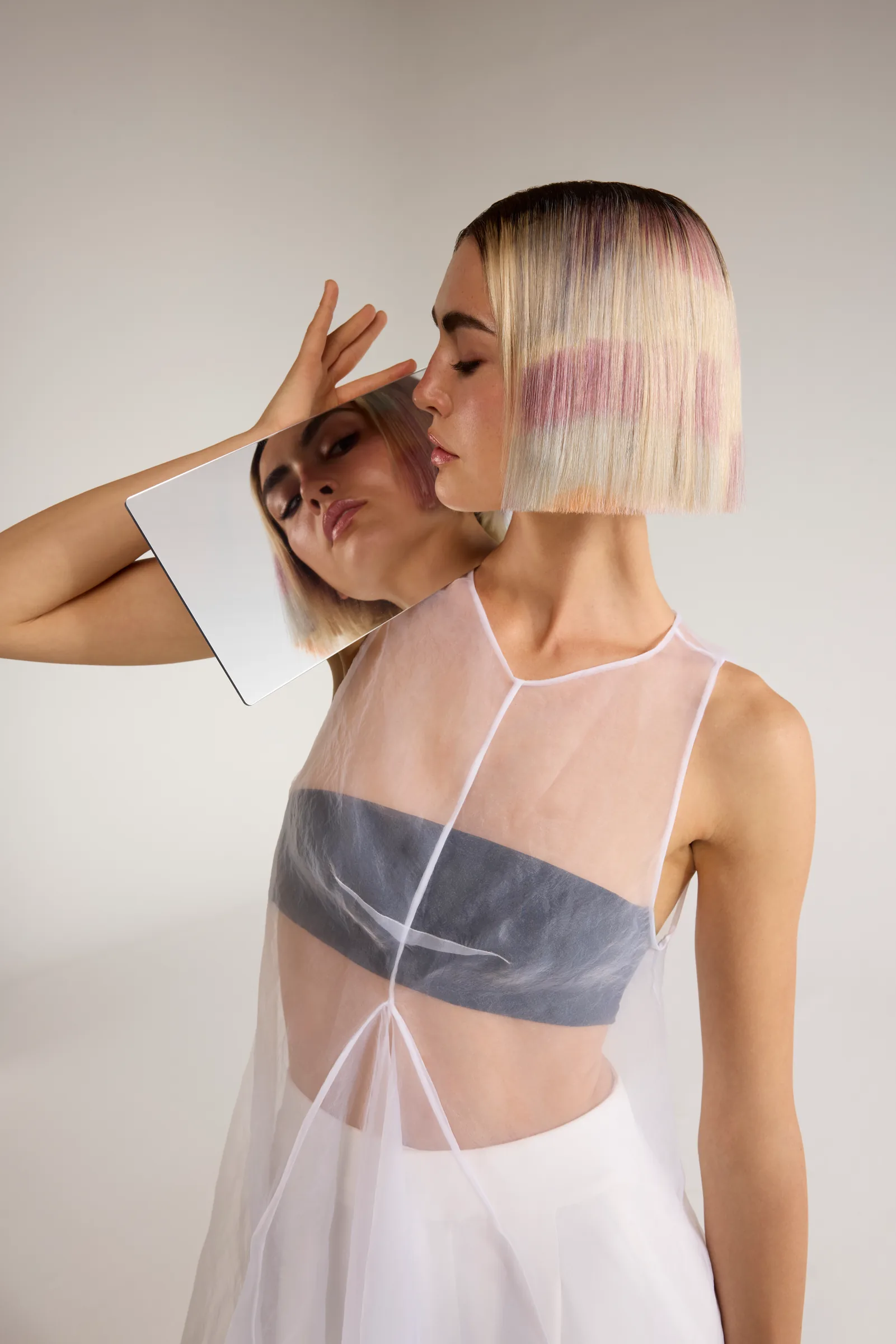Model with a silver and pastel bob and a sheer top
